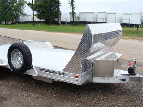 towing a skid steer with featherlite 3110|3110 flatbed trailer.